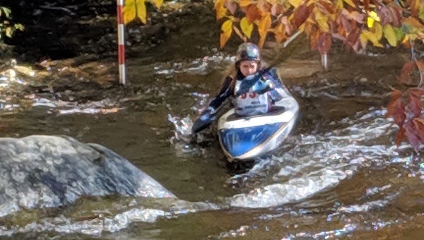 Slalom kayaker running the gates at Sunnyside Paddle Park on Bald Eagle Creek in autumn